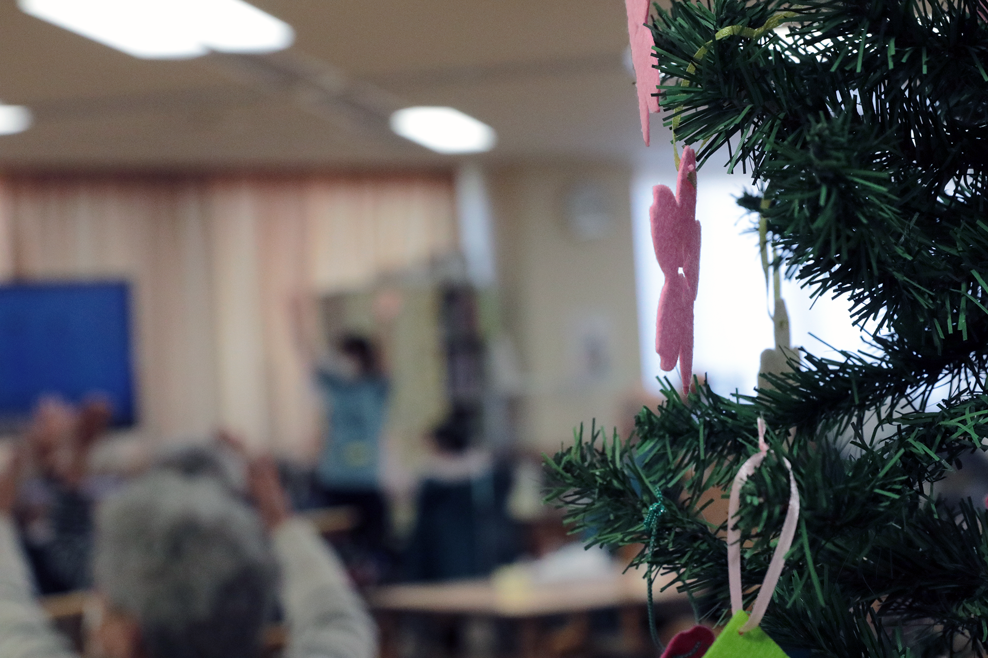 クリスマスツリーの装飾が飾られた共用スペースで、入居者が活動している様子。